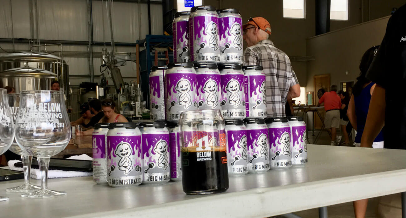 Beer-Chronicle-Houston-Craft-Beer-Review-11-Below-Big-Mistake-In-Glass-In-Front-Of-Can-Stack