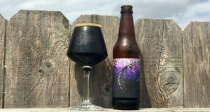 Beer-Chronicle-Houston-Craft-Beer-Review-Copperhead-Black-Venom-Full-Teku-Glass-Next-To-Bottle-On-Fence