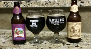Beer-Chronicle-Houston-Craft-Beer-Review-Saint-Arnold-Bishops-Barrel-17-vs-Divine-Reserve-16-Side-By-Side-Full-Glasses-Next-To-Bottles